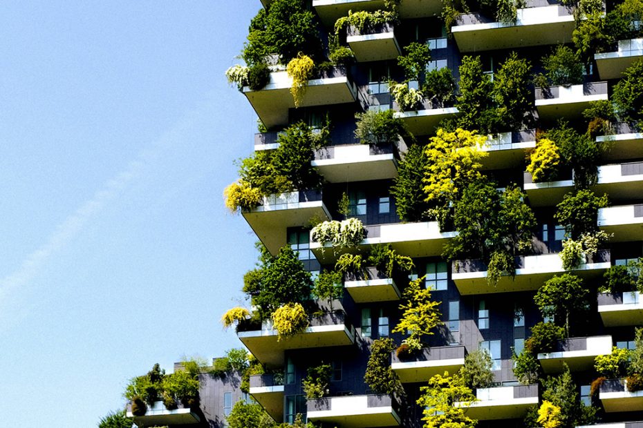 Edificio vertical ajardinado con abundante vegetación integrada, ejemplo de arquitectura sostenible y renaturalización urbana.