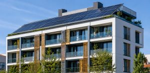 Edificio sostenible con paneles solares, vegetación integrada y diseño eficiente orientado a la descarbonización.