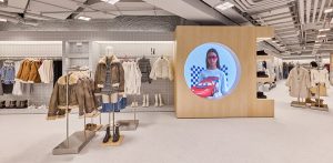 Espacio comercial moderno equipado con percheros, maniquíes y pantallas con contenido visual digital.