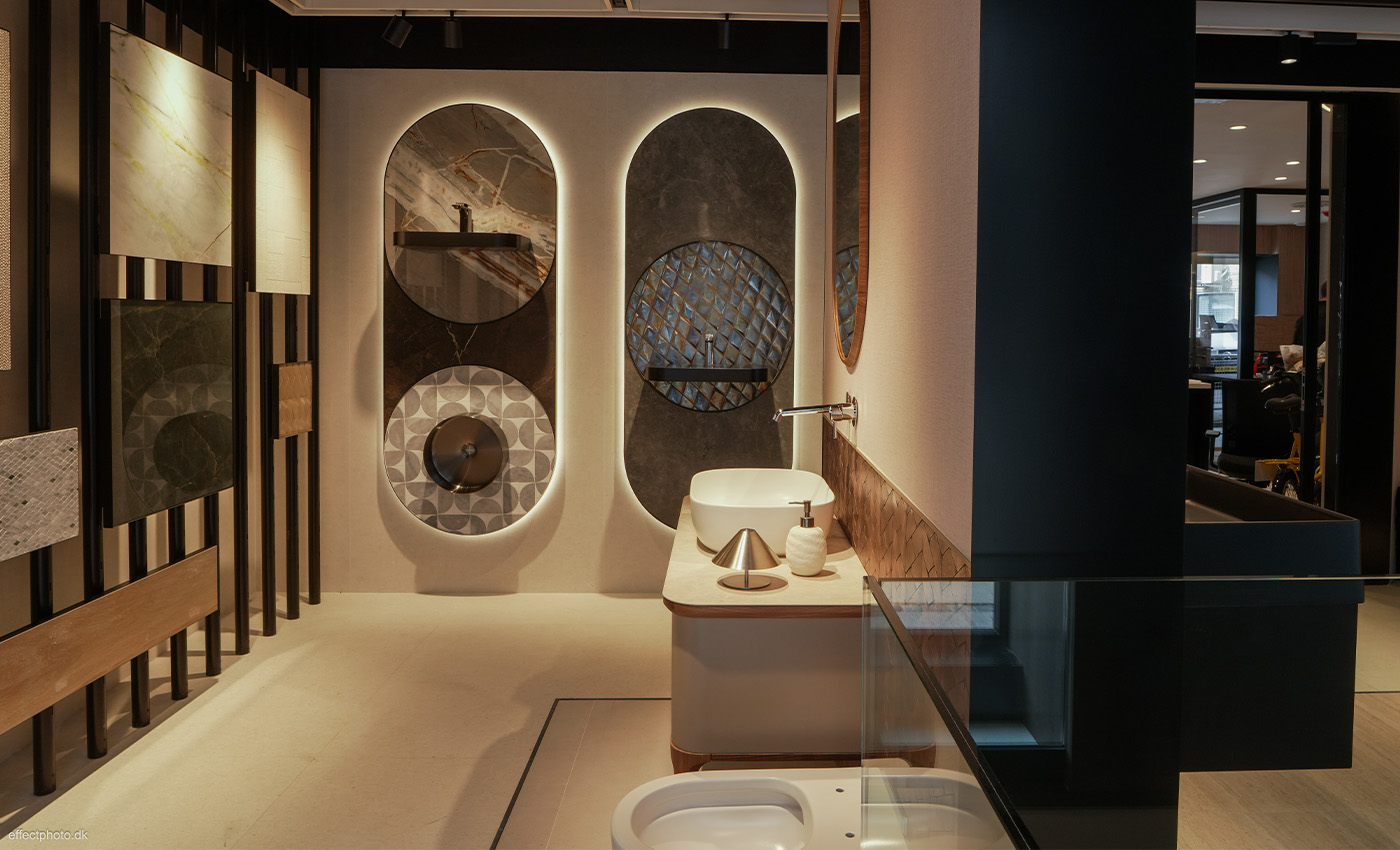 Exposición interior comercial de azulejos elegantes, lavabos modernos y lujosos accesorios de baño iluminados.