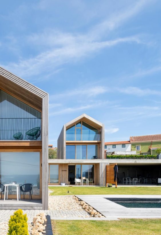 Vista exterior de vivienda moderna junto a piscina con cielo azul despejado.