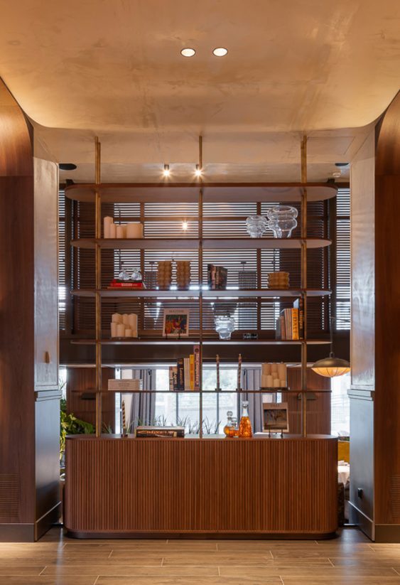 Primer plano de mueble de cocina verde oliva con platos apilados y estantes superiores.